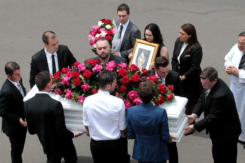 A group of people carrying a coffin.