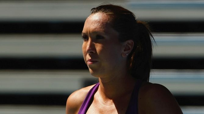 Serbian Jelena Jankovic stares determinedly into the distance while she balances tennis balls