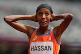 Woman with her hands on her head after winning race at the Olympics 