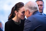 Jacinda Ardern and Scott Morrison lean toward each other and touch noses in a custom known as a hongi
