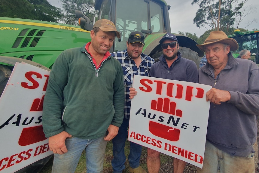 A group of farmers with 'Stop AusNet' signs