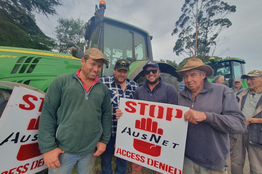 Eine Gruppe von Bauern mit „Stop AusNet“-Schildern