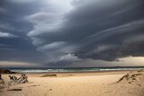 Storm clouds loom over a beach.