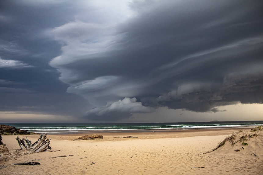 Storm clouds loom over beach.