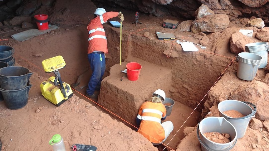 people in a cave measuring and digging