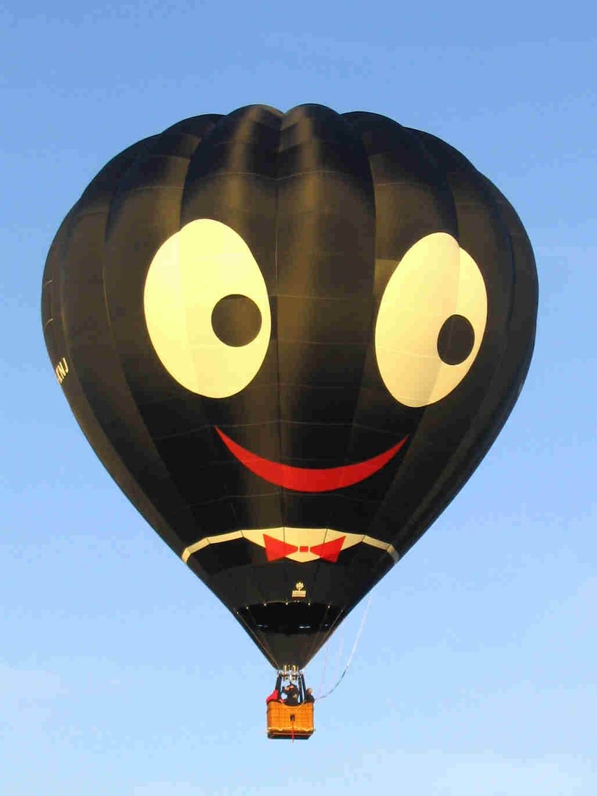 A black balloon depicting a face with wide white eyes and bright red lips.