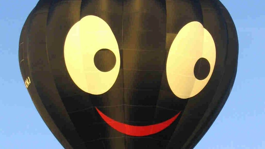 A black balloon depicting a face with wide white eyes and bright red lips.