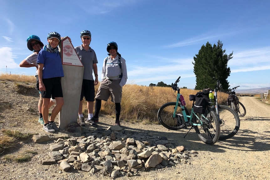 Two men and two women in cycling gear pose on a cycling track in Otago Central.