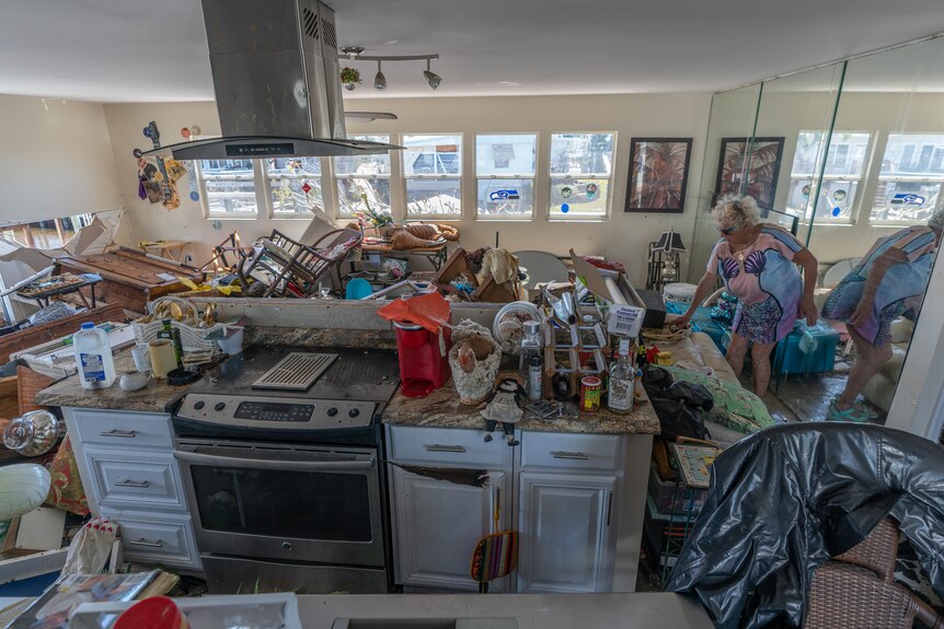 Rubble in a living room and kitchen following a hurricane. 