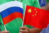 A child holds the national flags of Russia and China.