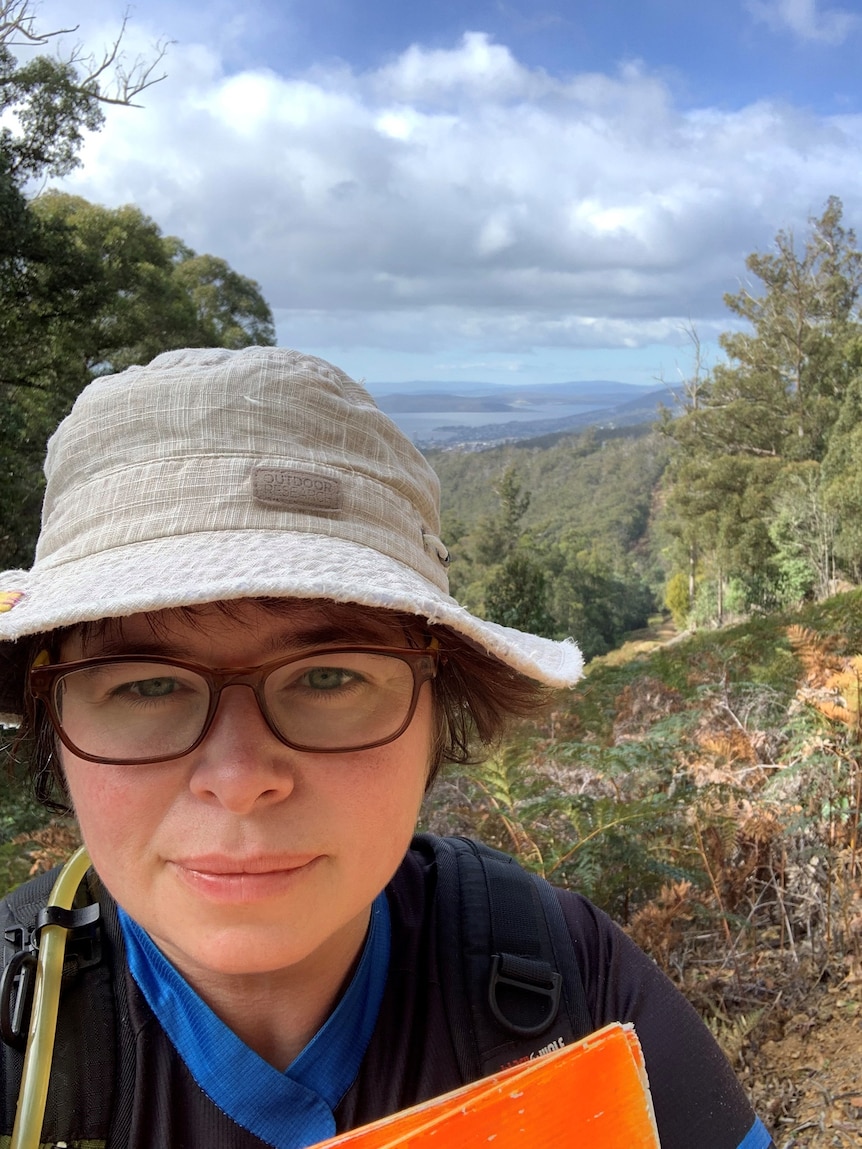 A woman in a wide brimmed hat in the bush