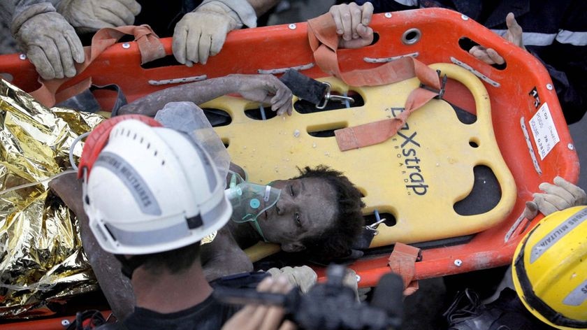 A Haitian girl is rescued by a French team after being in the rubble