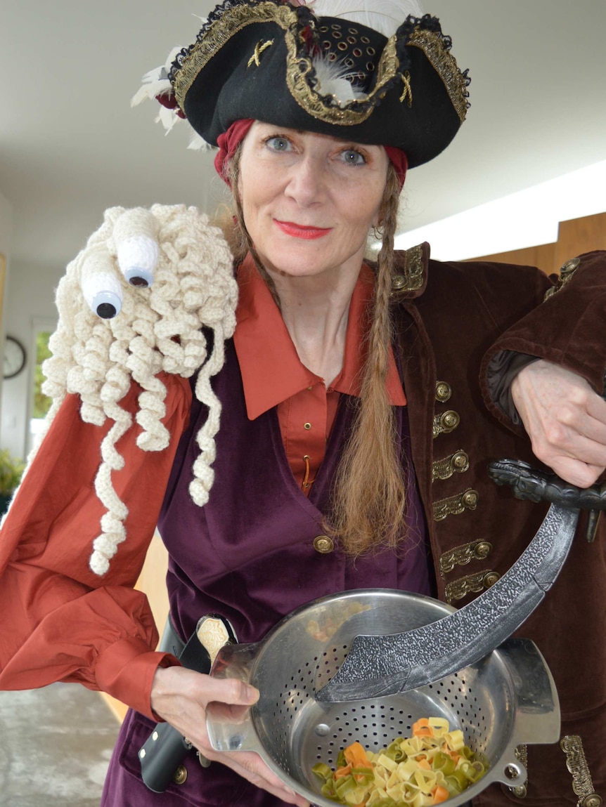 Karen Martyn dressed in a pirate costume holding a bowl of pasta