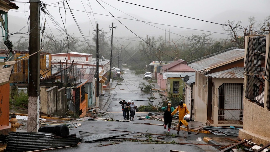 Rescue workers help people after the area was hit by Hurricane Maria.