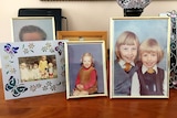 A collection of family pictures on a sideboard.