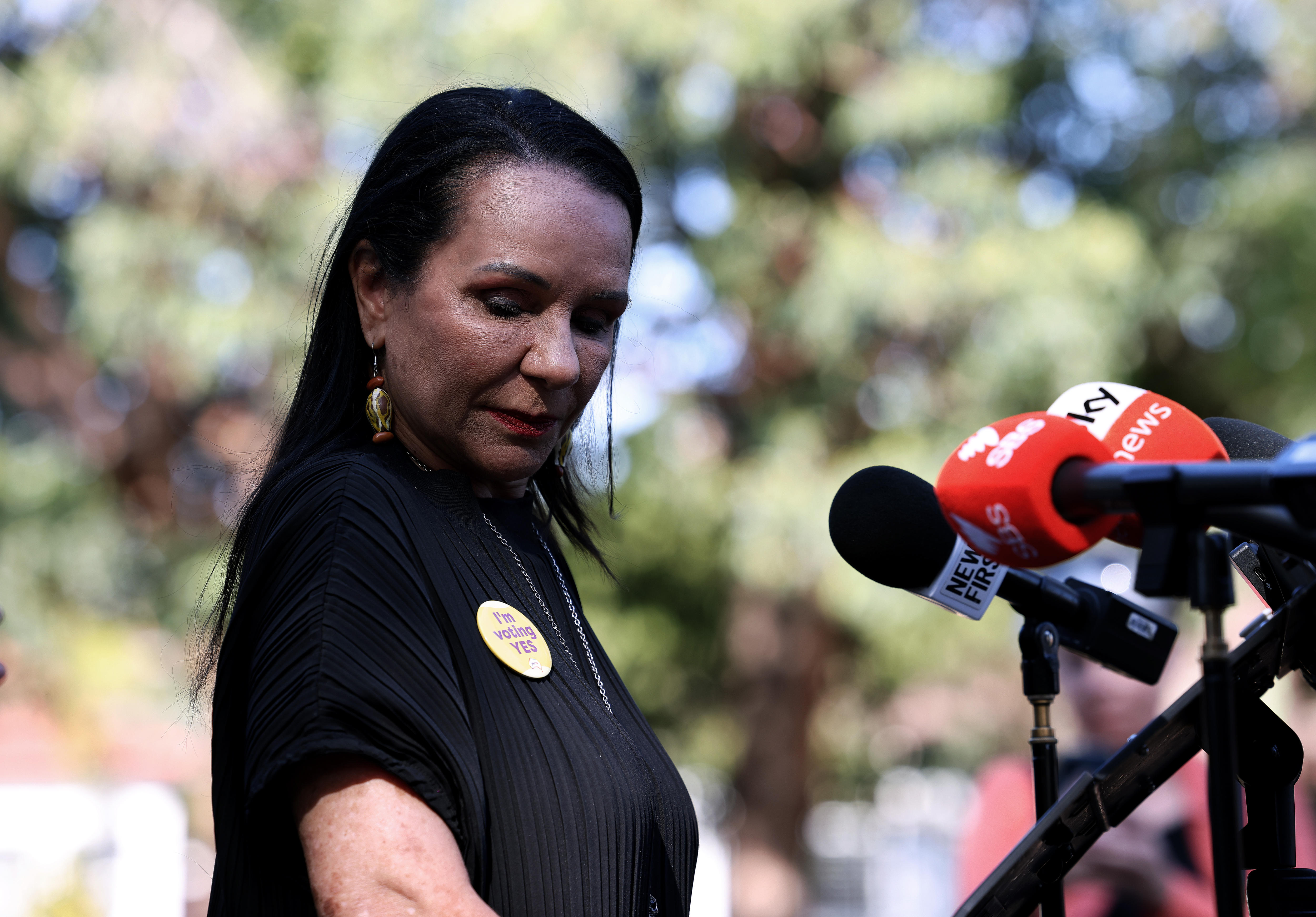 Linda Burney with her head down wearing a Yes badge. 