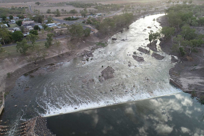 A drone shot of a weir with water running through it.