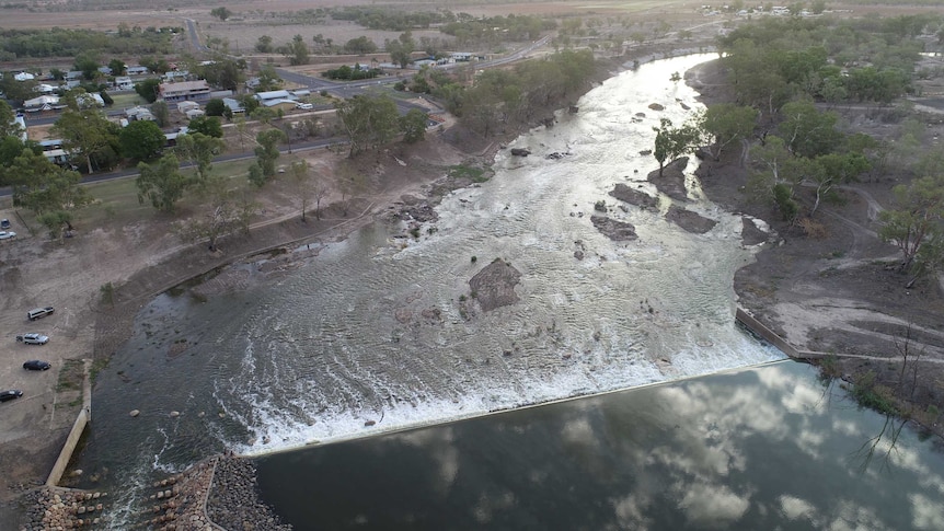 A drone shot of a weir with water running through it.