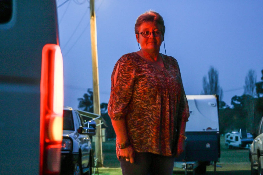 Gulgong showground caretaker Colleen Bailey standing behind Nightrider Community Bus