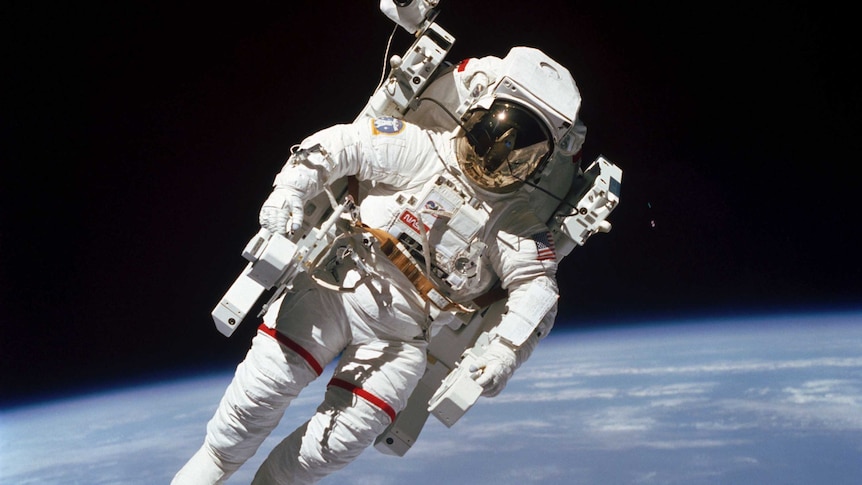 Bruce McCandless II is seen floating in space with earth in the background.