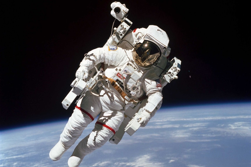 Bruce McCandless II is seen floating in space with earth in the background.