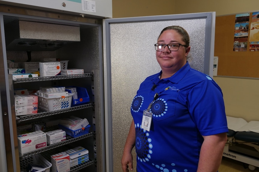 Nurse Danielle Gill standing in front of a vaccine fridge