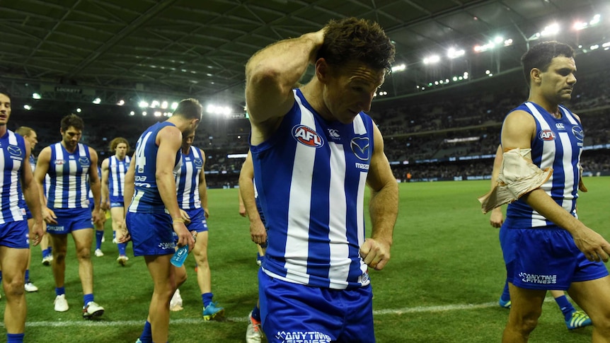 The Kangaroos walk off the ground after losing to Geelong at Docklands