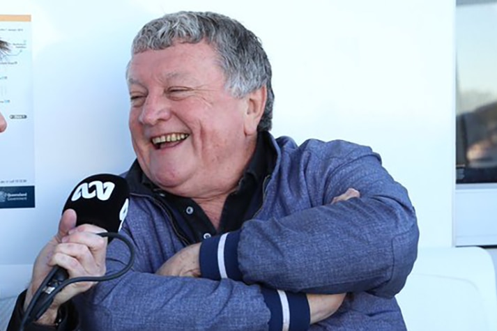 Former Brisbane lord mayor Jim Soorley smiles as he speaks to an ABC presenter's microphone