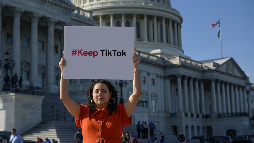 A woman holds up sign outside of Capitol Hill reading #KeepTikTok 