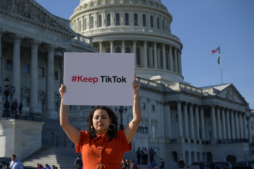 A woman holds up sign outside of Capitol Hill reading #KeepTikTok 