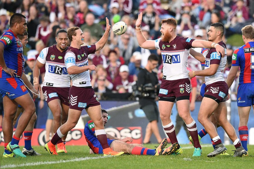 Manly Sea Eagles celebrate a try against the Newcastle Knights