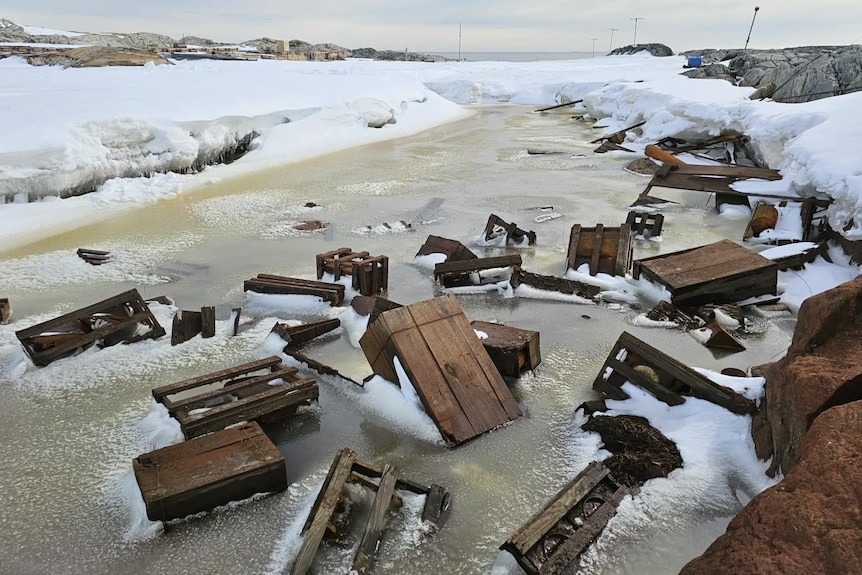 Timber crates in thawed, refrozen lake