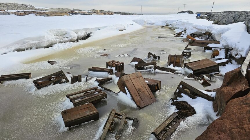 Timber crates in thawed, refrozen lake