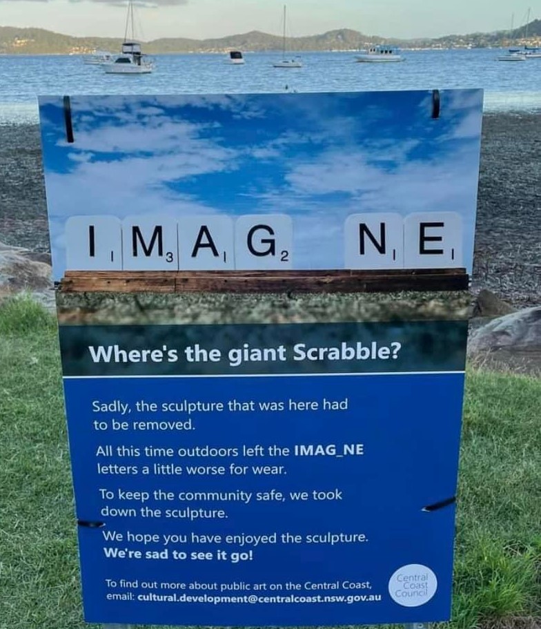 A sign on a beach explaining why a beloved sculpture is no longer there.