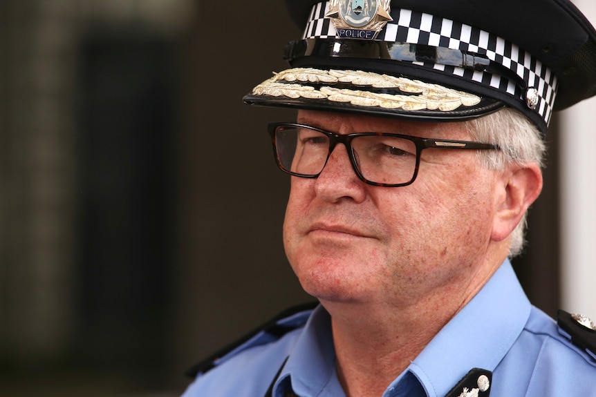 Police Commissioner Chris Dawson, side profile. He wears his uniform and hat and has black glasses