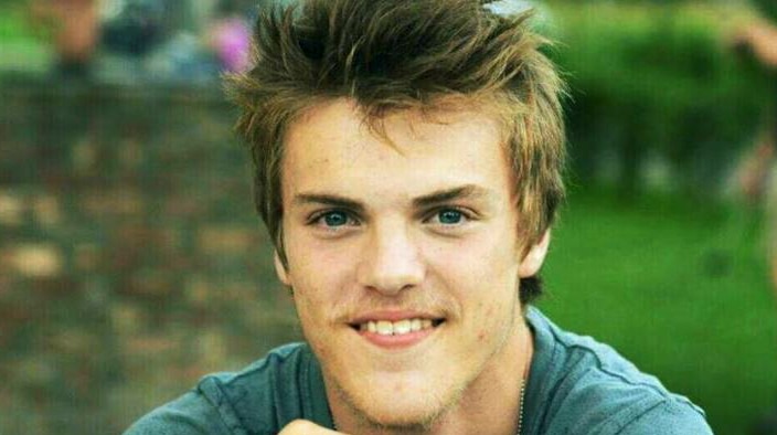 A young man wearing a green t-shirt.