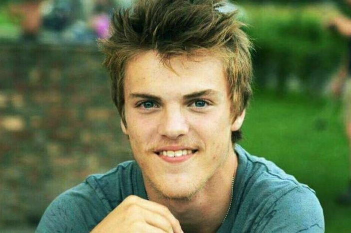 A young man wearing a green t-shirt.