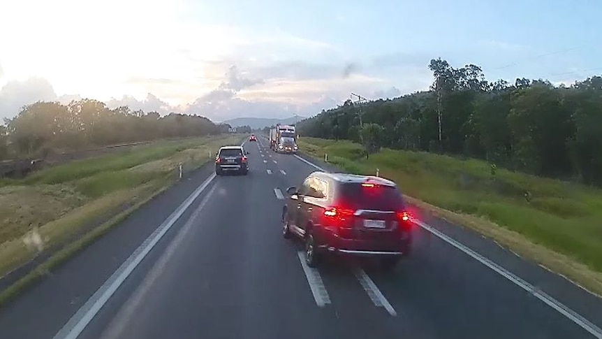 Dashcam footage of a stolen car about to crash into another on the Bruce Highway north of Townsville.