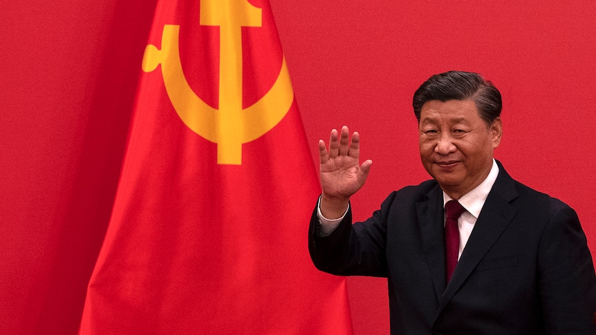 Chinese President Xi Jinping waves in front of Chinese flag