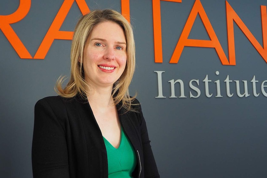 Danielle Wood stands in front of the Grattan Institute sign.