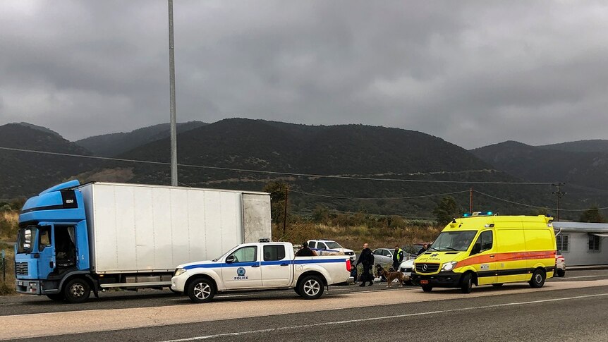 A truck, police and ambulance at the side of the motorway in Greece.