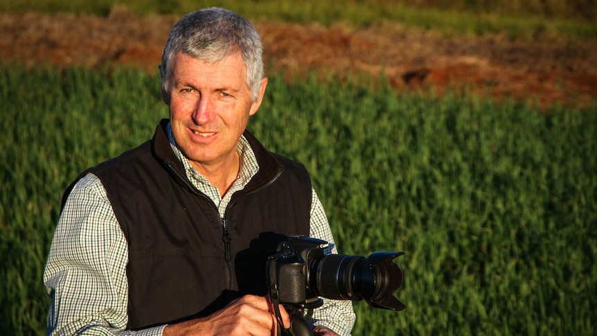 Kingaroy resident John Dalton with a digital SLR camera in a paddock in southern Queensland