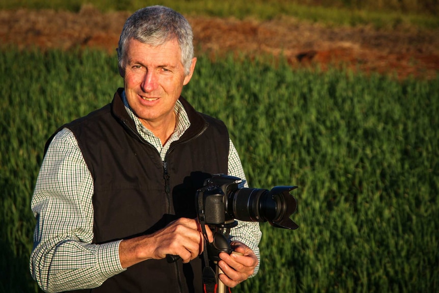 Kingaroy resident John Dalton with a digital SLR camera in a paddock in southern Queensland