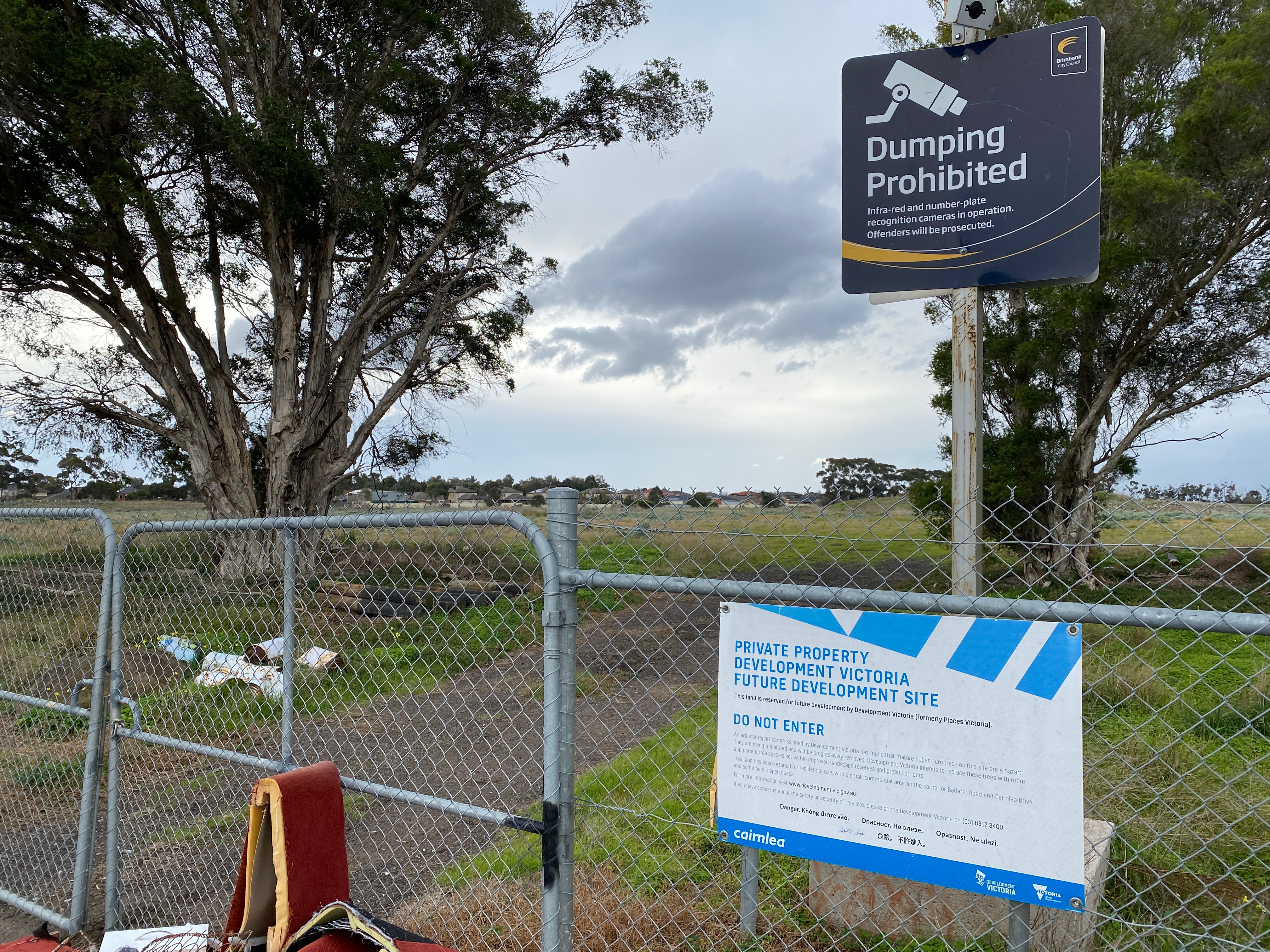 A fence with a sign stating it is private property and dumping is prohibited