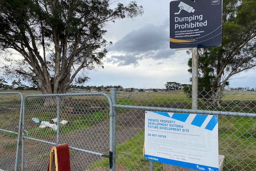 A fence with a sign stating it is private property and dumping is prohibited