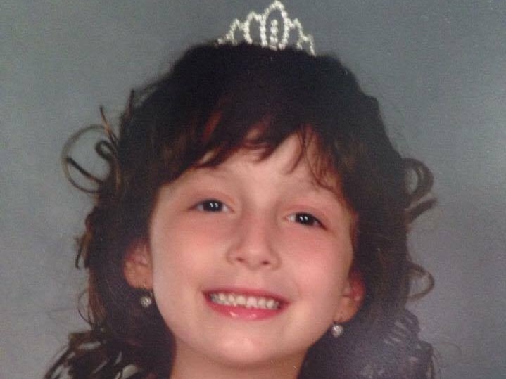 Sabrina di Lembo as a child wearing a crown and a white dress.