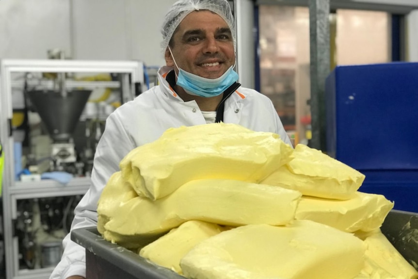 A bin of butter, pushed by a worker.