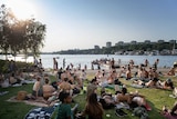 Swedes gather in the sun around a lake.