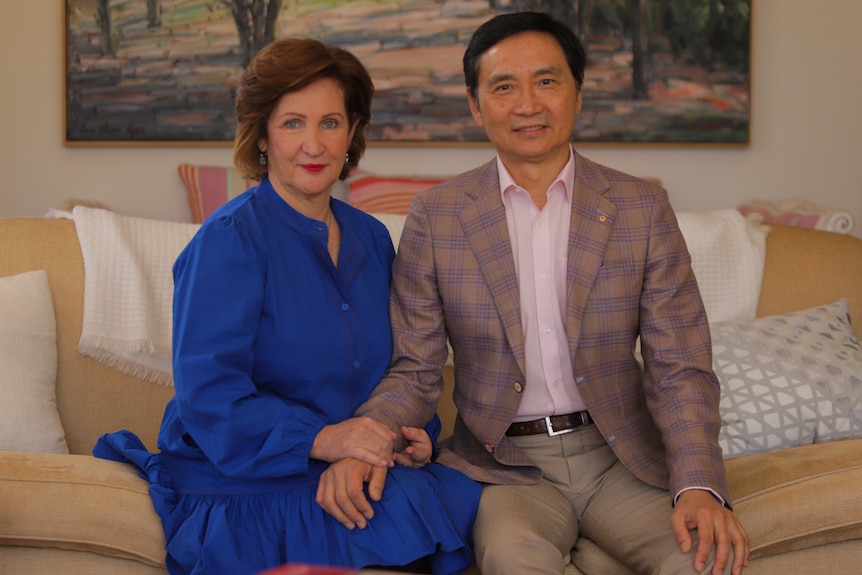 Mary and Li Cunxin sit on a couch