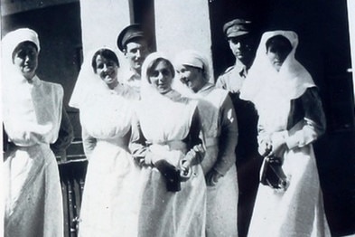 Black and white image of five nurses and and two orderlies.